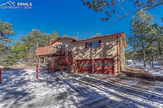 snow covered property with a garage