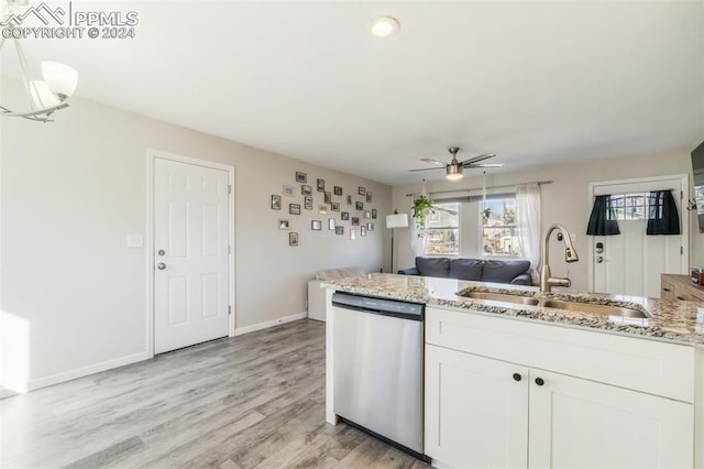 kitchen with sink, stainless steel dishwasher, light stone countertops, light wood-type flooring, and white cabinetry