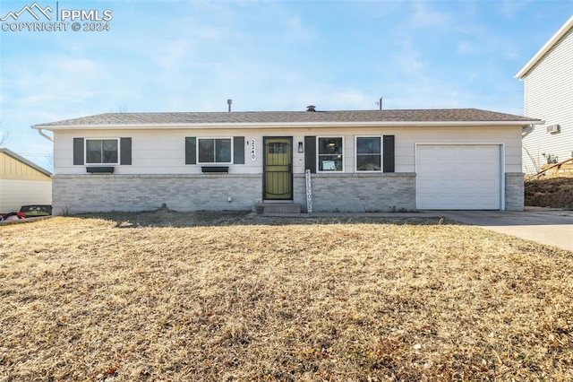 ranch-style house with a garage and a front lawn