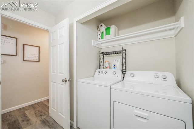 laundry area with washer and dryer and hardwood / wood-style flooring