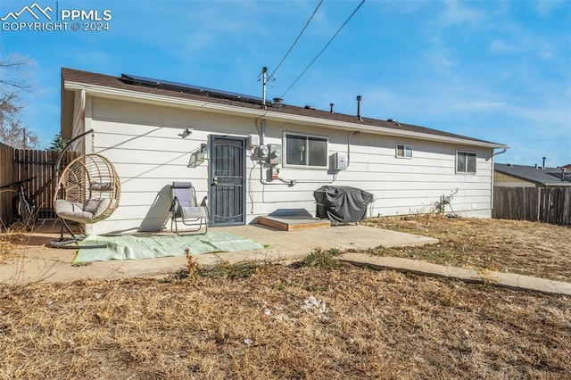 back of house featuring a patio area and solar panels