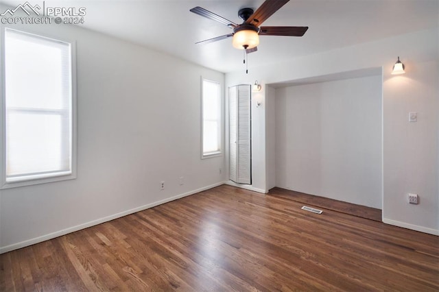 empty room with dark hardwood / wood-style flooring and ceiling fan