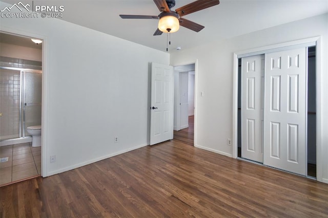 unfurnished bedroom featuring ceiling fan, a closet, dark hardwood / wood-style flooring, and ensuite bath