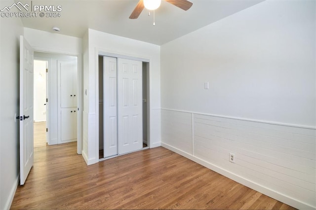 unfurnished bedroom featuring ceiling fan, a closet, and wood-type flooring