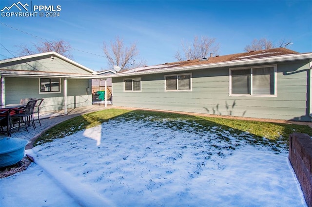 snow covered house featuring a patio