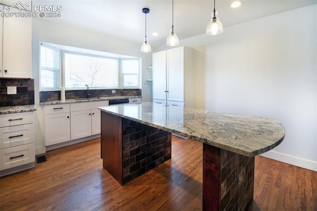 kitchen with a center island, sink, white cabinetry, and dark wood-type flooring