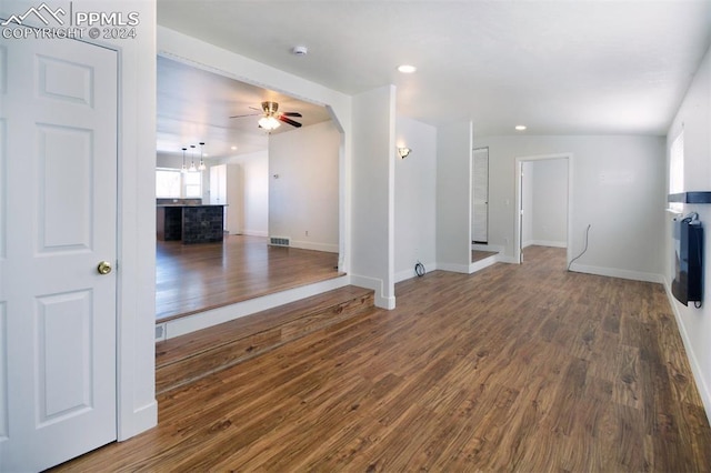 unfurnished living room featuring dark hardwood / wood-style floors and ceiling fan