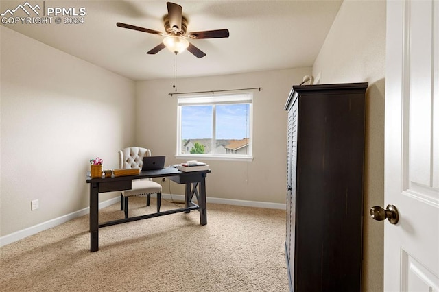 carpeted office featuring a ceiling fan and baseboards