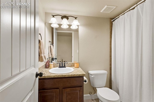 bathroom with visible vents, vanity, and toilet