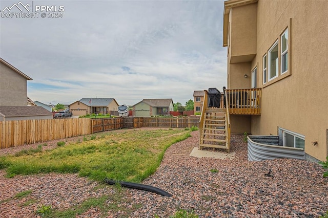 view of yard with a residential view, a fenced backyard, and stairs