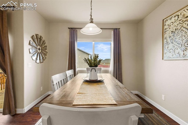 dining room with baseboards and dark wood-type flooring