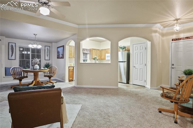 carpeted living room with ceiling fan with notable chandelier and crown molding