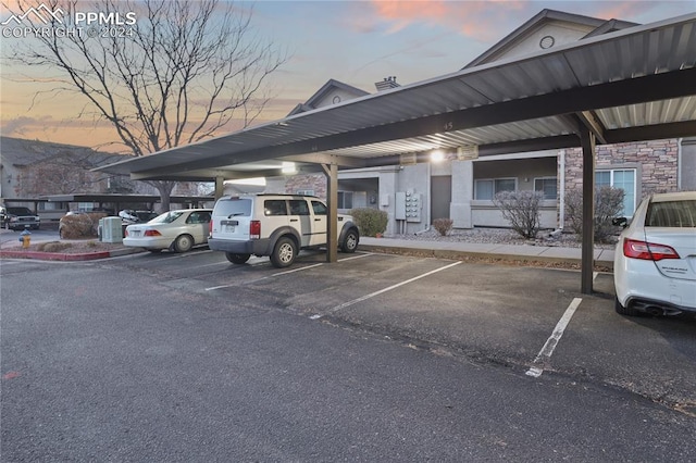 parking at dusk featuring a carport