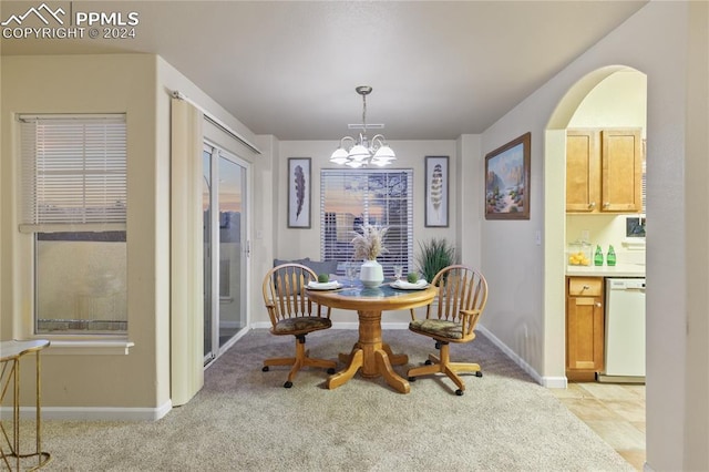 carpeted dining space with a notable chandelier