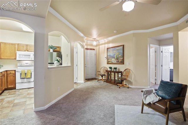 sitting room with ceiling fan, light colored carpet, and ornamental molding