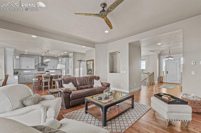 living room featuring ceiling fan and light hardwood / wood-style floors
