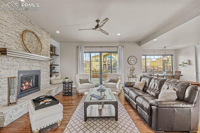 living room with ceiling fan, wood-type flooring, a fireplace, and a wealth of natural light