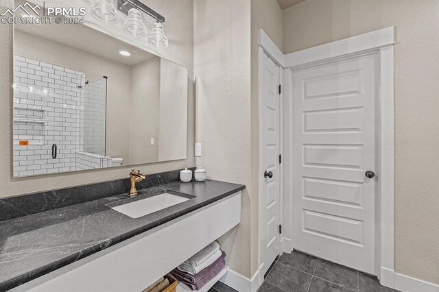bathroom featuring vanity, a shower with door, and tile patterned floors