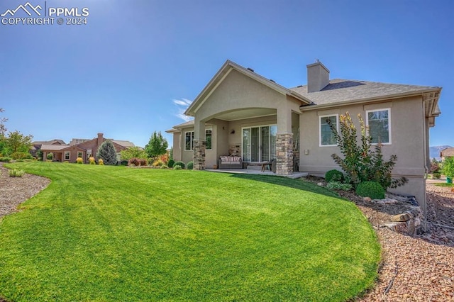 back of house featuring a patio area and a lawn