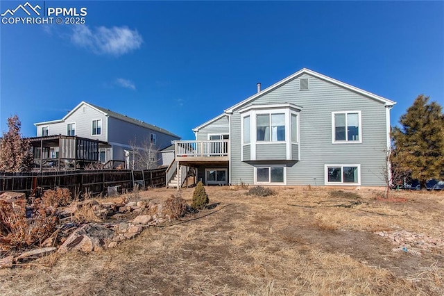 rear view of house featuring a wooden deck