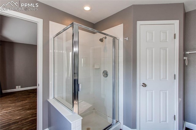 bathroom featuring an enclosed shower and wood-type flooring