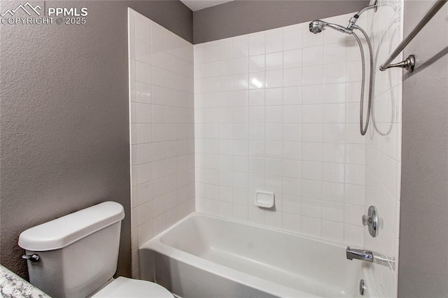 bathroom with toilet and tiled shower / bath