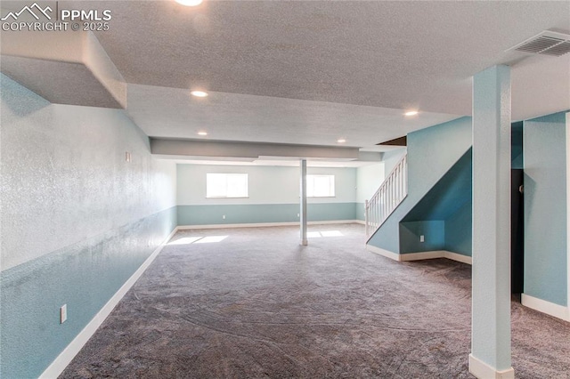 basement with carpet and a textured ceiling