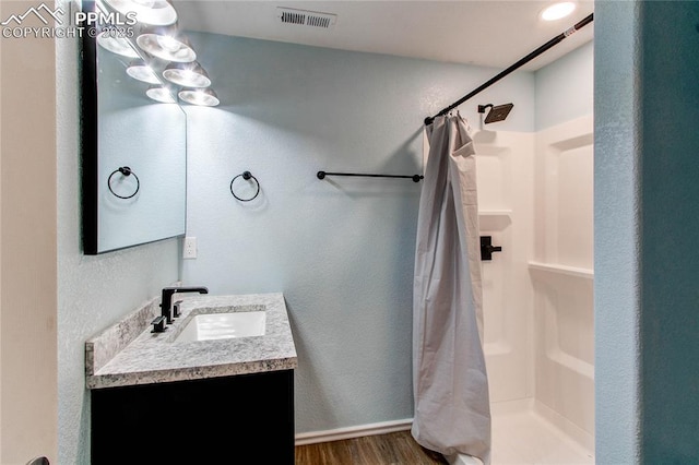 bathroom featuring curtained shower, vanity, and hardwood / wood-style flooring