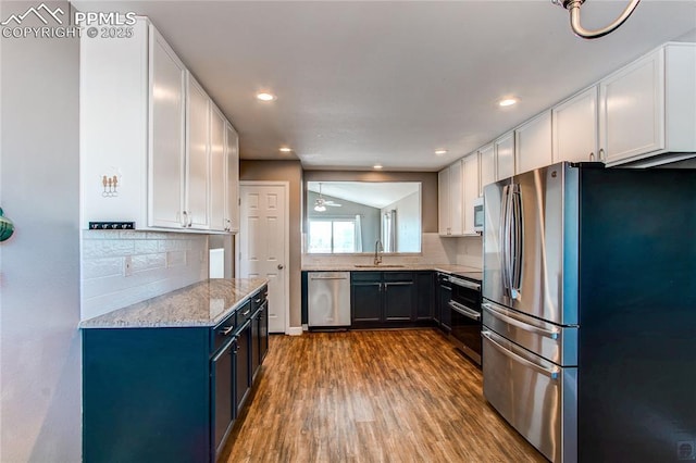 kitchen featuring backsplash, stainless steel appliances, white cabinetry, and sink