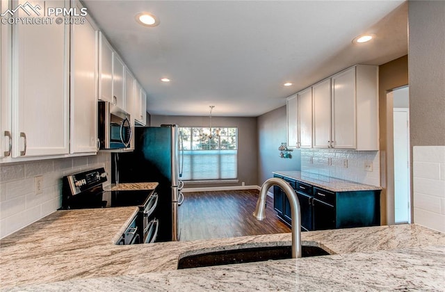 kitchen featuring light stone countertops, stainless steel appliances, white cabinetry, and sink