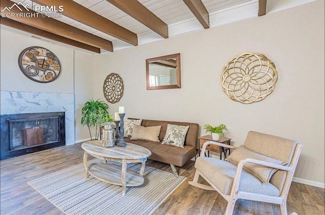 living room featuring beamed ceiling, hardwood / wood-style floors, wood ceiling, and a tiled fireplace