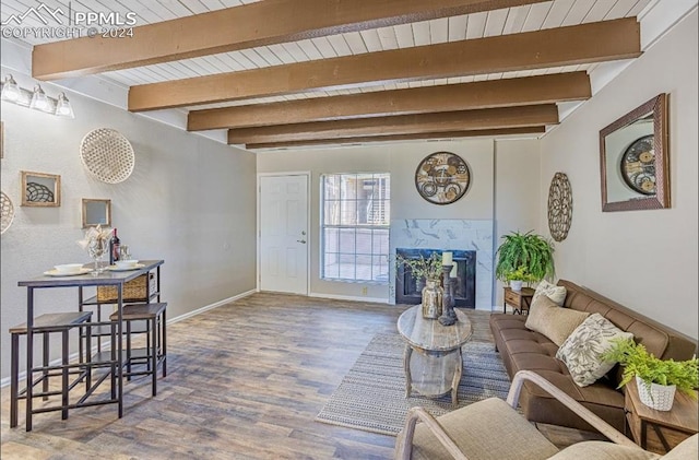 living room with beamed ceiling, wood-type flooring, and a high end fireplace