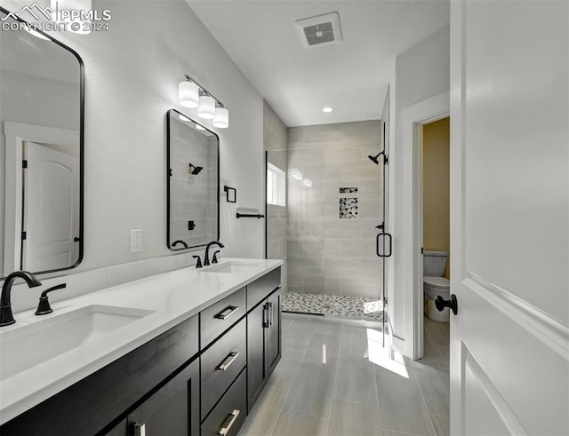 bathroom featuring tile patterned flooring, vanity, toilet, and walk in shower