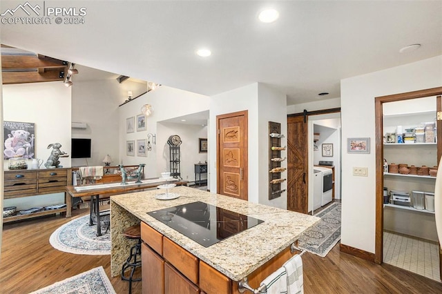 kitchen featuring a barn door, black electric cooktop, a kitchen island, and dark hardwood / wood-style floors