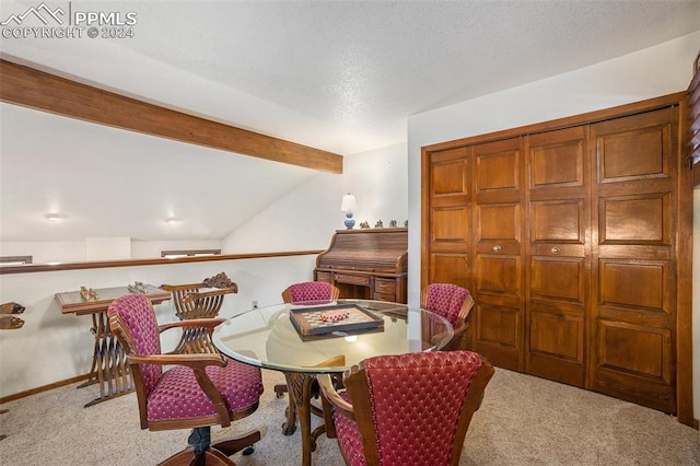 dining room featuring lofted ceiling with beams and light carpet