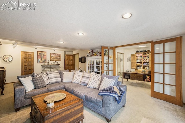 carpeted living room with a textured ceiling and french doors