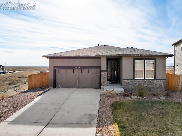 prairie-style home featuring a front lawn and a garage