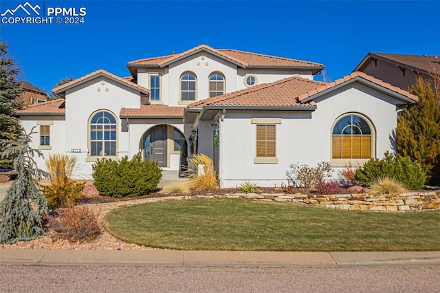 mediterranean / spanish-style home featuring a front yard