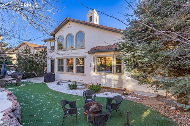 rear view of house featuring a lawn, a patio, and an outdoor fire pit