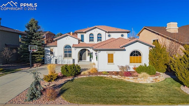 mediterranean / spanish-style house with a front lawn