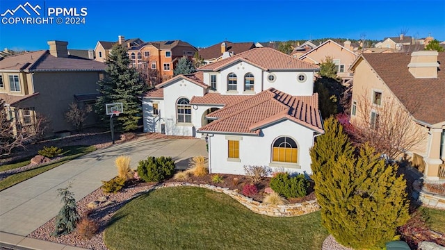 mediterranean / spanish home featuring a front lawn