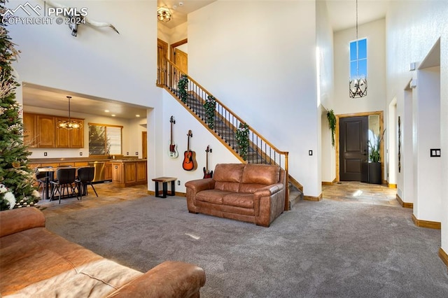 carpeted living room with a towering ceiling and a notable chandelier