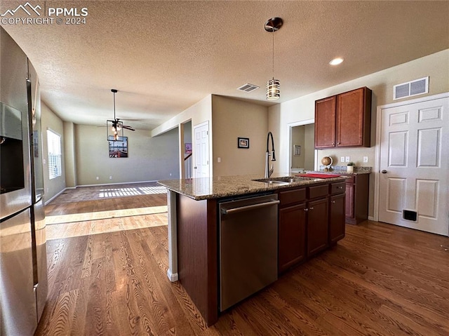 kitchen with visible vents, stainless steel appliances, dark wood-type flooring, and decorative light fixtures