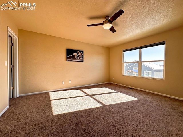 empty room with a ceiling fan, carpet, a textured ceiling, and baseboards