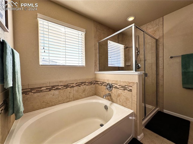 bathroom with tile patterned flooring, plus walk in shower, and a textured ceiling