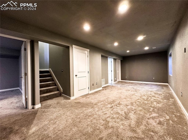 finished below grade area featuring recessed lighting, carpet flooring, visible vents, baseboards, and stairs