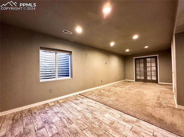 empty room featuring french doors and hardwood / wood-style floors