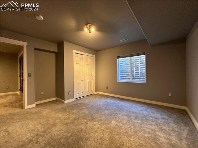 unfurnished bedroom with multiple closets, carpet flooring, visible vents, and baseboards