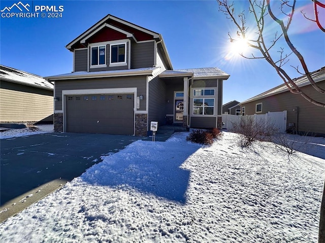 view of front of house with a garage, stone siding, fence, and driveway