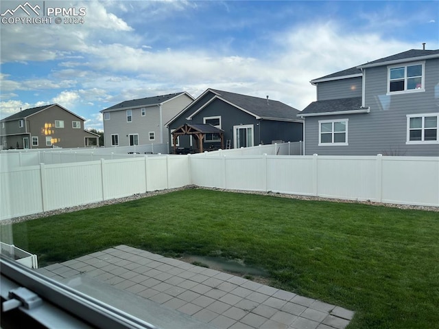 view of yard featuring a patio, a fenced backyard, and a residential view